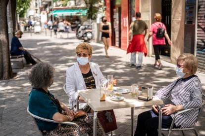 Isabel Cortes, junto a dos amigas, en la terraza de un bar de la calle Antonio López, en el barrio de Usera, Madrid, la semana pasada.