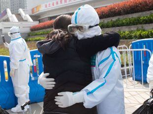 El personal médico abraza a los pacientes dados de alta en el Hospital Wuchang Fangcang, en Wuhan.