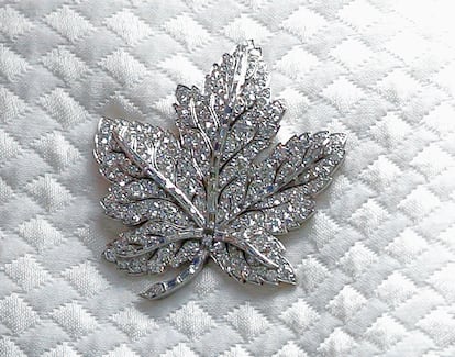 The pin in the shape of a maple leaf, a symbol of Canada, on Elizabeth II's lapel during a visit to Canada House in London in July 2017.