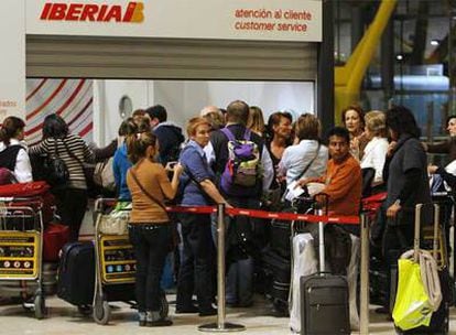 Pasajeros damnificados por los retrasos en Barajas, ayer en la cola del mostrador de atención al cliente de Iberia.