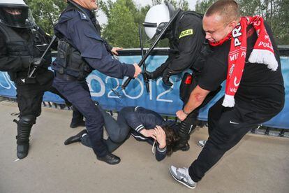 Policiás antidisturbios intervienen durante unos altercados entre aficionados rusos y polacos en las inmediaciones del estadio Nacional de Varsovia.