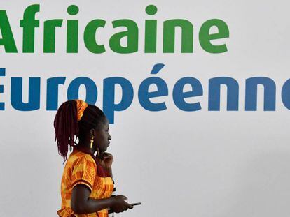 Una mujer, ante el cartel de la cumbre &Aacute;frica-Europa de Costa de Marfil.
