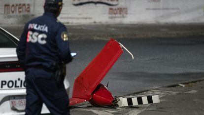 Un policía inspecciona una parte de la cola del helicóptero que se desplomó la tarde del 14 de abril, en Ciudad de México.