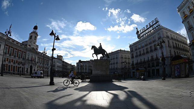 Un repartidor cruza en bicicleta la madrileña Puerta del Sol, vacía, el pasado sábado.