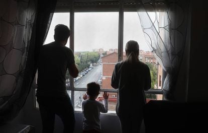 Miguel, Dara y su hijo se asoman a la ventana del piso que okupan.