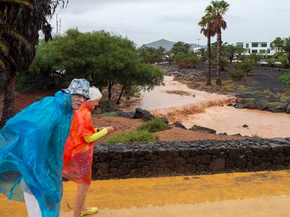 Unos turistas observan el barranco que desemboca en la playa de Las Cucharas, en Costa Teguise (Lanzarote).