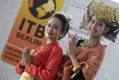 Dos mujeres indonesias posan frente a un cartel que anuncia la ITB Berlín 2013, que tendrá como país anfitrión a Indonesia. EFE/Archivo