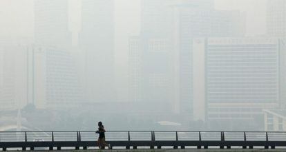 Una mujer corriendo por Singapur, este jueves.