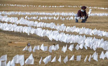 Una mujer coloca una de las 10.000 banderas blancas en un homenaje a las víctimas del coronavirus en el estado de Georgia, este domingo.