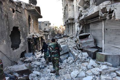 Soldados del Ejército sirio caminan en medio de una gran destrucción en el barrio de Bustan al-Basha, en Alepo, en el transcurso de su asalto para retomar la ciudad del control de los combatientes rebeldes.