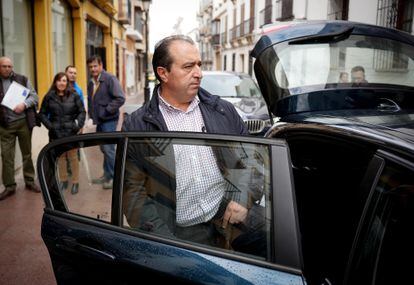 El antiguo agente del BBVA y tesorero del PP de Lucena (Córdoba), Gregorio Flores, sale de los juzgados este lunes. En segundo termino, varios de los estafados.