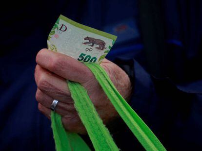 Fotografía de archivo en la que se registró un billete de quinientos pesos argentinos en la mano de una ciudadana al hacer sus compras, en la Ciudad de Buenos Aires (Argentina). EFE/Demian Alday Estévez