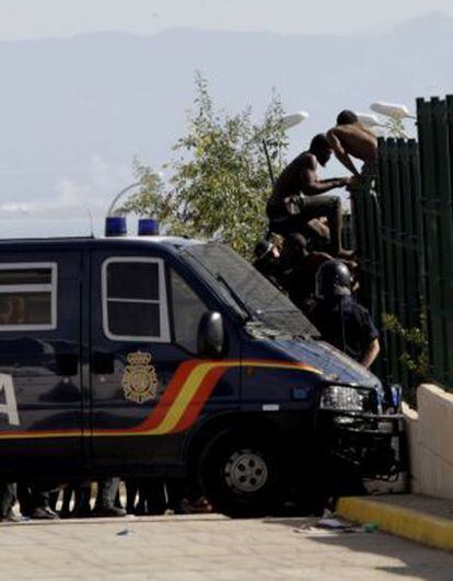 Varios inmigrantes intentan huir de la policía saltando la valla de la estación de tratamiento de agua en Melilla.