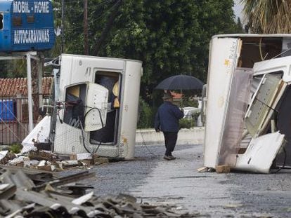 Un hombre pasea entre dos caravanas destrozadas por el temporal. 
