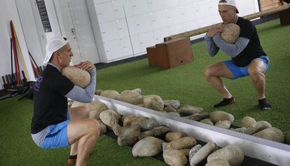 Un home fa exercicis de carregar pesos amb pedres en un gimnàs de 'paleotraining' a Sabadell