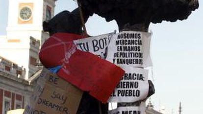 El oso y el madroño de la madrileña Puerta del Sol permanece forrado con carteles con diversos lemas.