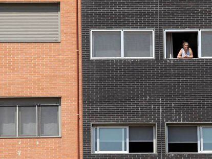 Una vecina se asoma a una ventana del edificio Memoria, de la EMVS, en la calle de Barrileros.