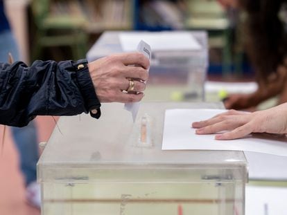 Una persona mete su voto en la urna en un colegio electoral, a 28 de mayo de 2023, en Madrid (España).