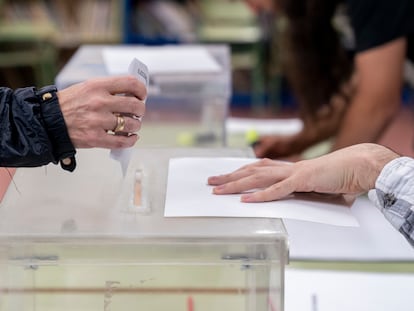 Una persona mete su voto en la urna en un colegio electoral, a 28 de mayo de 2023, en Madrid (España).