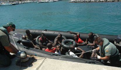 Varios guardias civiles llevan al puerto de Ceuta a inmigrantes que trataban de llegar a la ciudad a nado