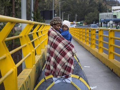 Una madre con su hijo en el puente fronterizo.