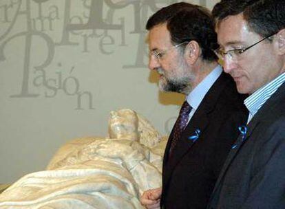 El presidente del PP, Mariano Rajoy, y el presidente provincial y candidato popular a la alcaldía de Teruel, Manuel Blasco, ante uno de los sepulcros en alabastro donde se guardan los cuerpos momificados atribuidos a los Amantes de Teruel.