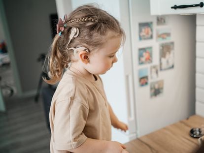 Una niña pequeña con un implante auditivo.