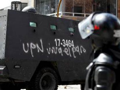 Un miembro del Escuadrón Movil Anti Disturbios (ESMAD), observa una tanqueta con grafitis en Bogotá (Colombia) en apoyo al paro agrario convocado por algunos sectores agrarios que reclaman soluciones a sus problemas y el cumplimiento de los acuerdos que pusieron fin a las protestas del año pasado.