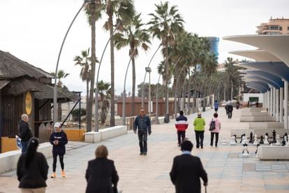 Varias personas caminan por el paseo marítimo de Estepona (Málaga). 

