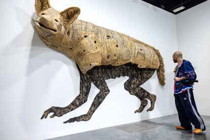 A visitor to Art Basel Miami Beach, in front of the piece 'Coyota/e', by Hector Dionicio Mendoza, last Wednesday.