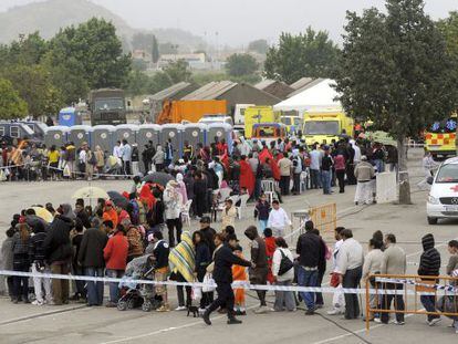 Cientos de ciudadanos hacen cola para que técnicos del Ayuntamiento de Lorca, de Cruz Roja y de Protección Civil comprueben los datos y la situación de cada uno de los 2.687 acogidos en el mayor de los tres campamentos instalados tras los terremotos.