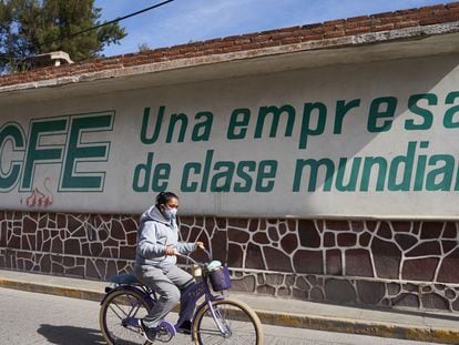 Una mujer pasa junto a una oficina de la Comisión Federal de Electricidad, en Villa de Reyes, San Luis Potosí.