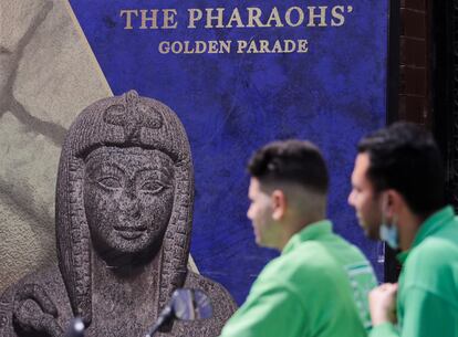 Two men spend this week in Cairo in front of a sign announcing the parade.