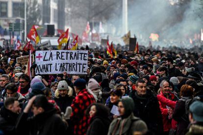 A protester holds a sign reading 'retirement before arthritis' in Lyon, southeastern France, on January 19, 2023.