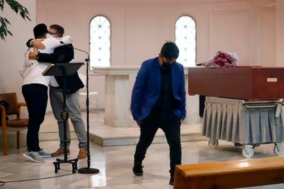 Matías hugs the pastor during the funeral of his sister Abigail, in Terrassa, at the beginning of October.  In the foreground, his brother Ezequiel. 