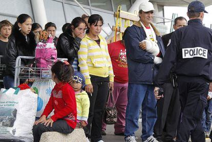 Un grupo de gitanos espera en el aeropuerto francés de Lille para embarcar en el avión que los llevará de regreso a Rumania.