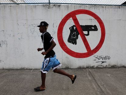 Un hombre corre frente a un graffiti en Guayaquil (Ecuador), el 12 de enero.