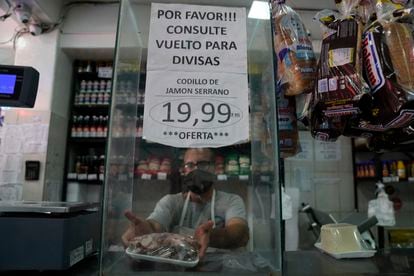 Cartel en una tienda de Caracas por la nueva ley del Gobierno que aplica un impuesto del 3% a las transacciones hechas con monedas extranjeras.