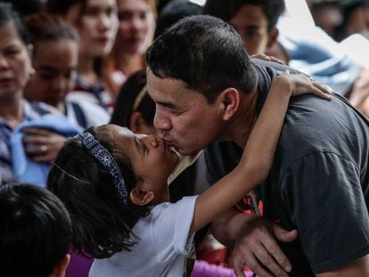 Una niña besa a su padre que acaba de llegar de viaje en Manila.