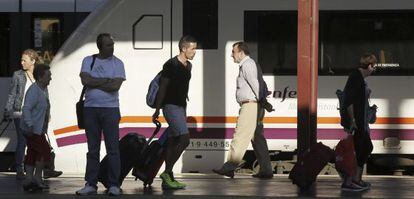 Varios pasajeros de tren en la estación de Chamartín (Madrid).