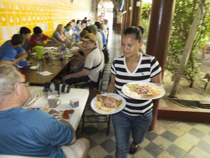 Irma Urbina, con discapacidad auditiva, sirve desayunos a un grupo de estudiantes norteamericanos en el Café de las Sonrisas, único en su estilo en todo América Latina.


