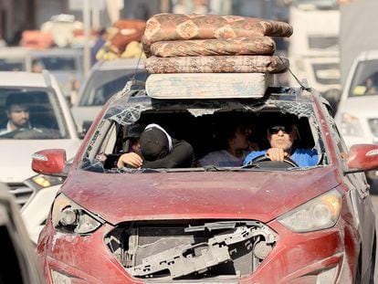 Un vehículo seriamente dañado es usado por una familia para huir del norte de la Franja de Gaza este viernes.