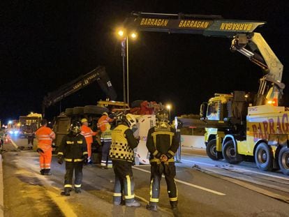 Operarios de la grúa, bomberos y agentes de la Guardia Civil, a primera hora de la mañana durante los trabajos para retirar el camión accidentado en el kilómetro 84 de la M-50.