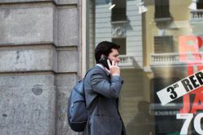 Un usuario habla por el tel&eacute;fono m&oacute;vil en una calle de Madrid.