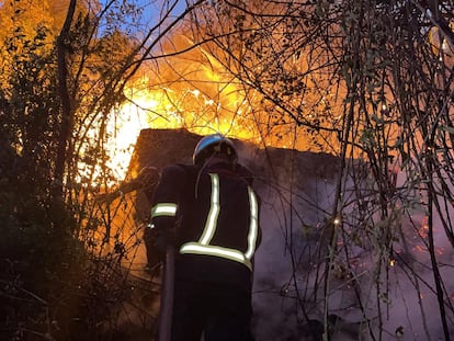 Los bomberos intentan apagar el incendio originado el sábado junto al pantano de San Juan.