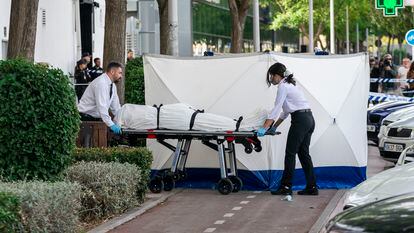 Dos trabajadores de la funeraria levantan el cadáver del hombre asesinado este lunes en una discoteca en Fuenlabrada (Madrid).