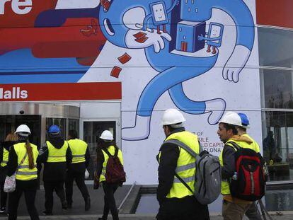 Un grupo de trabajadores accede a uno de los edificios donde se celebra el Mobile World Congress, en Barcelona.