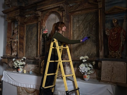 Aurora Galisteo, autora de la tesis sobre los retablos de las comarcas de Alba y Aliste, toma muestras de la pintura de altar mayor de la iglesia de Tolilla.