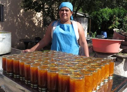 Ana Cuello posa junto a docenas de frascos de mermelada de naranja.