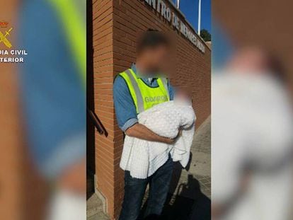 Un agente con el bebé que fue 'vendido' a la pareja de hombres de Almería.